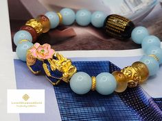 Gift yourself or your loveonce this beautiful bracelet. Crafted with 24 Karat Real Gold, Agate, and Blue Angelite. Pixiu changes color based on Pixius surrounding temperature.   Metal: 24K Gold (Au999) Colour: Yellow Gold Gold Weight: Approximately 4.43grams Citrine Size: Approximately 10mm Metal is Made of Real 24K Gold. Not Gold Filled. Not Gold Plated. Not Gold Vermeil. 🧧Pixiu is a powerful Feng Shui symbol of wealth. It is believed that wearing the symbol of Pixiu brings money and good fortune to its wearer. This mythical creature is also thought to protect people from losing wealth. It also provides you not only physical protection, but also spiritual protection. 🧧Money Ball is a symbol for good fortune, happiness, and success. It is also used as Feng Shui protection in warding off Gold Beaded Good Luck Bracelets, Luxury Bracelets For Festivals As Gifts, Luxury Bracelets For Festivals Gift, Gold Bracelets With Round Beads For Good Luck, Traditional Gold Bracelets As Gifts, Traditional Yellow Gold Beaded Bracelets As Gift, Gold Spiritual Bracelets As Gifts, Traditional Gold Bracelet, Feng Shui Bracelet