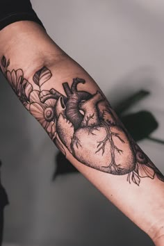 a heart and flowers tattoo on the arm