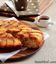 a pineapple upside down cake on a wooden plate next to a cup of coffee