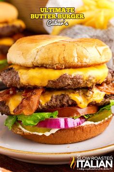 a cheeseburger with bacon, lettuce and tomato on it sitting on a plate