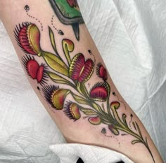 a woman's leg with flowers on it and a bird sitting on the branch