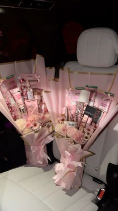 a bunch of pink flowers sitting in the back seat of a car with some ribbons on it