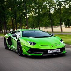 a green sports car driving down the road