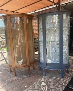 two glass curios sitting under an awning on a patio next to each other