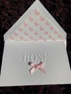 a white card with pink hearts on it and the word rose written in silver foil