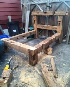 a bench made out of wood sitting on top of a driveway