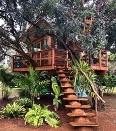 a tree house built into the side of a hill with stairs leading up to it