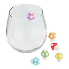 a glass filled with candy sitting next to small candies on top of each other