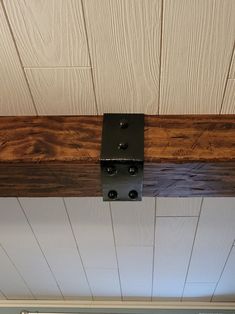 a close up of a wooden beam with metal brackets on the ceiling and wood paneling