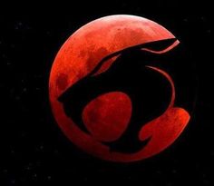 a red moon with a black silhouette of a lion on it's face in the dark night sky