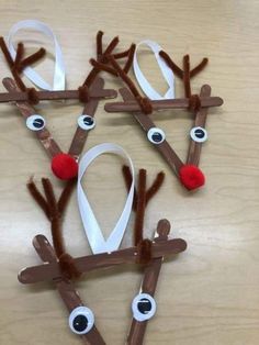 paper plate reindeers made out of brown sticks and white ribbon with red noses on them