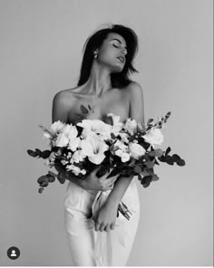 a black and white photo of a woman holding flowers