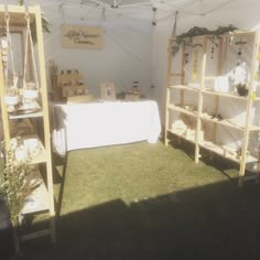 an outdoor market tent with tables and shelves