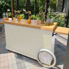 an outdoor bar with drinks on it and wheels around the bar area for people to sit at