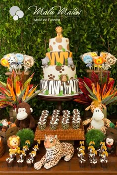 an animal themed birthday party with cake, cupcakes and jungle animals on the table