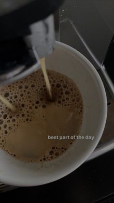 a cup of coffee being poured into a white bowl with the words best part of the day