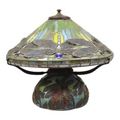 a lamp that is sitting on top of a table with a dragonfly design on it