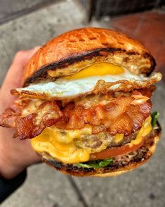 a bacon, egg and cheese sandwich in someone's hand