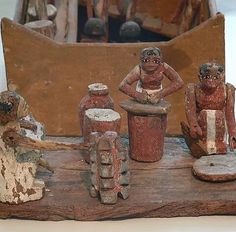 an old wooden table with clay figurines on it