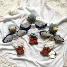 three crocheted stuffed animals sitting on top of a white blanket