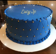 a blue birthday cake with gold dots and the words juicy up on it's side