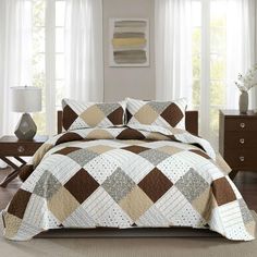 a bed covered in a brown and white quilt