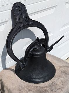 an old fashioned black metal bell sitting on top of a towel next to a garage door