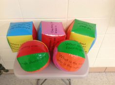 four colorful balls with writing on them sitting on a table in front of a white tile wall