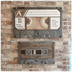 an old fashioned cassette player mounted to a brick wall next to another vintage tape recorder