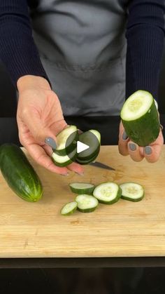 a person cutting cucumbers on a wooden board