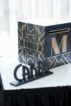 a black and gold box sitting on top of a table next to a pair of scissors