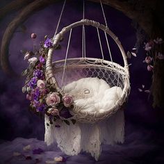 a white basket with flowers in it hanging from a tree branch on a purple background