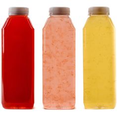 three plastic bottles with different colored liquids in them on a white background, one is empty and the other has no lid