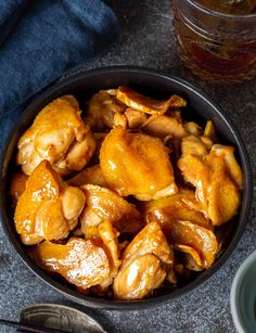 a bowl filled with chicken wings next to a cup of tea