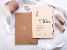 an assortment of wedding items including a ring, notebook and pen on a white surface