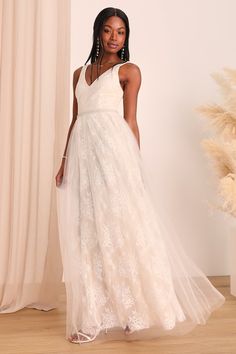 a woman standing in front of a curtain wearing a white dress