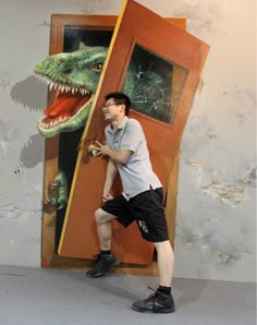 a man standing in front of a door with a dinosaur painting on it