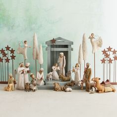 a nativity scene with figurines and stars on the wall behind them,