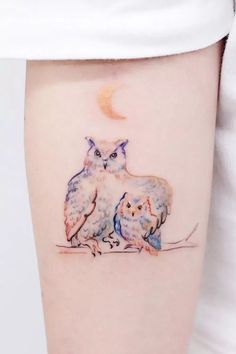 an owl and her baby sitting on the ground under a half - moon tattoo design