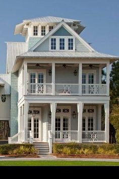 a large white house with lots of windows and balconies on the second floor