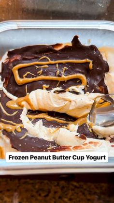 a frozen peanut butter cup yogurt is in a plastic container with spoons