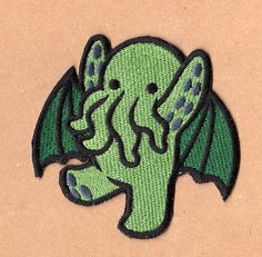 an embroidered patch with a green dragon on it