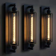 three light fixtures mounted to the side of a wall