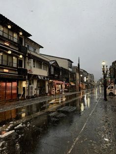 a wet city street with buildings on both sides