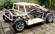 a car made out of wood sitting on the ground