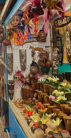 an outdoor market with lots of items for sale on the shelves and hanging from the ceiling