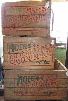 three wooden crates stacked on top of each other in front of a window with the word moirs written on them