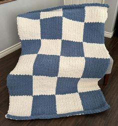 a blue and white blanket sitting on top of a wooden chair