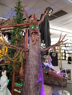 a fake tree in the middle of a store with decorations on it's branches