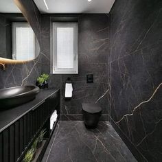 a bathroom with black marble walls and flooring